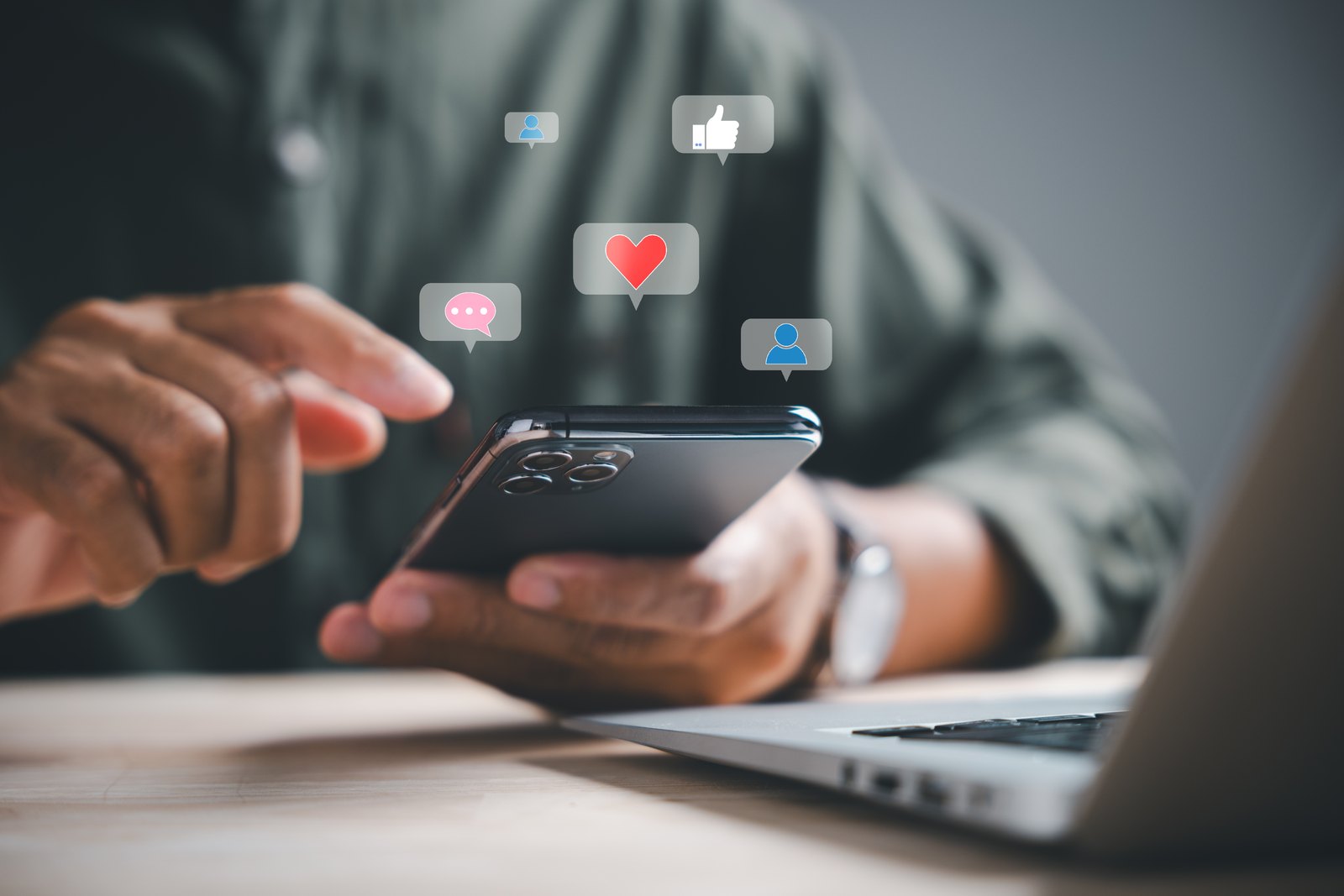 Person using a smartphone with social media icons above the screen